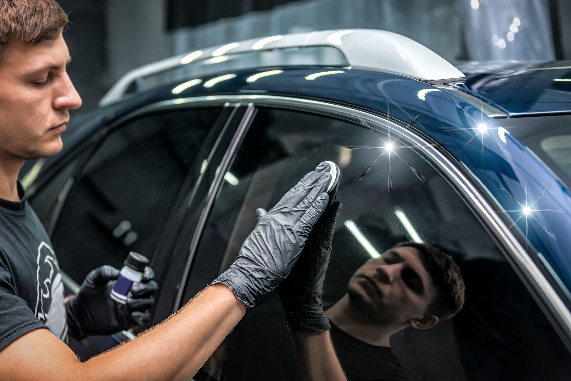 Technician applying coating to car window